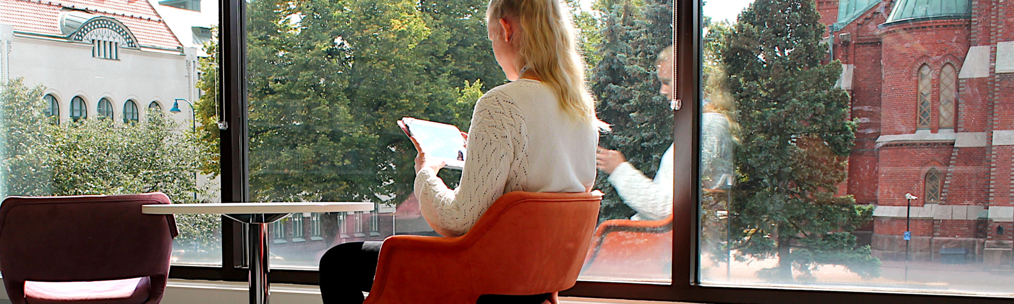 Nainen lukee e-kirjaa tabletilla