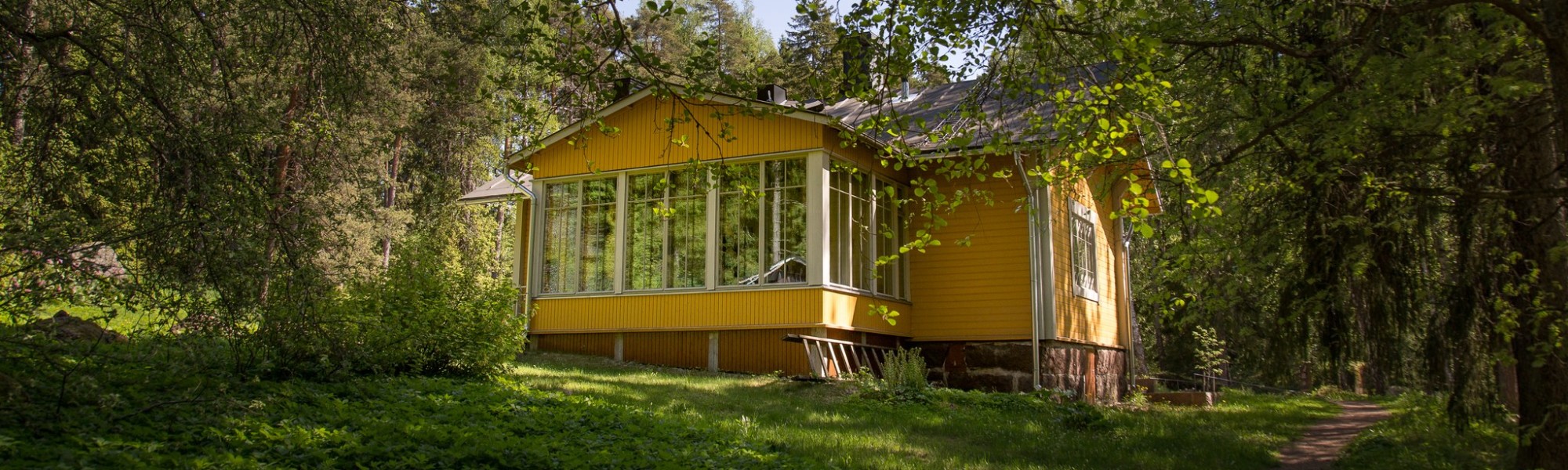 Keltainen talo kesämaisemassa
