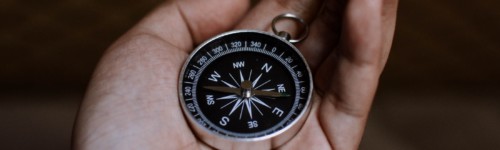 Kuvassa kompassi ihmisen kädessä