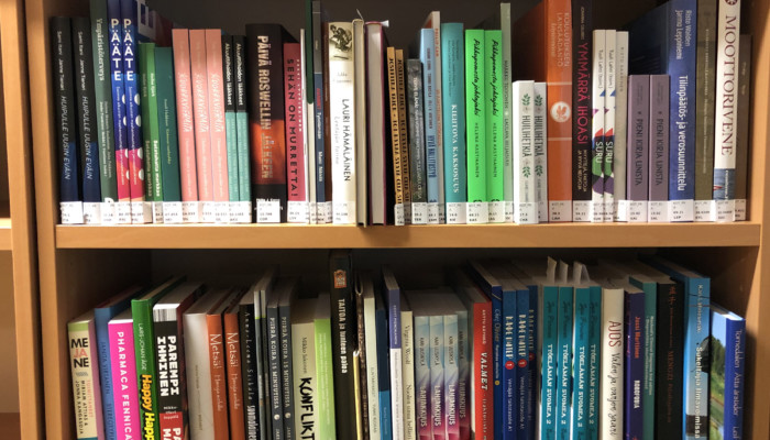 Kirjat ilman muovia hyllyssä.