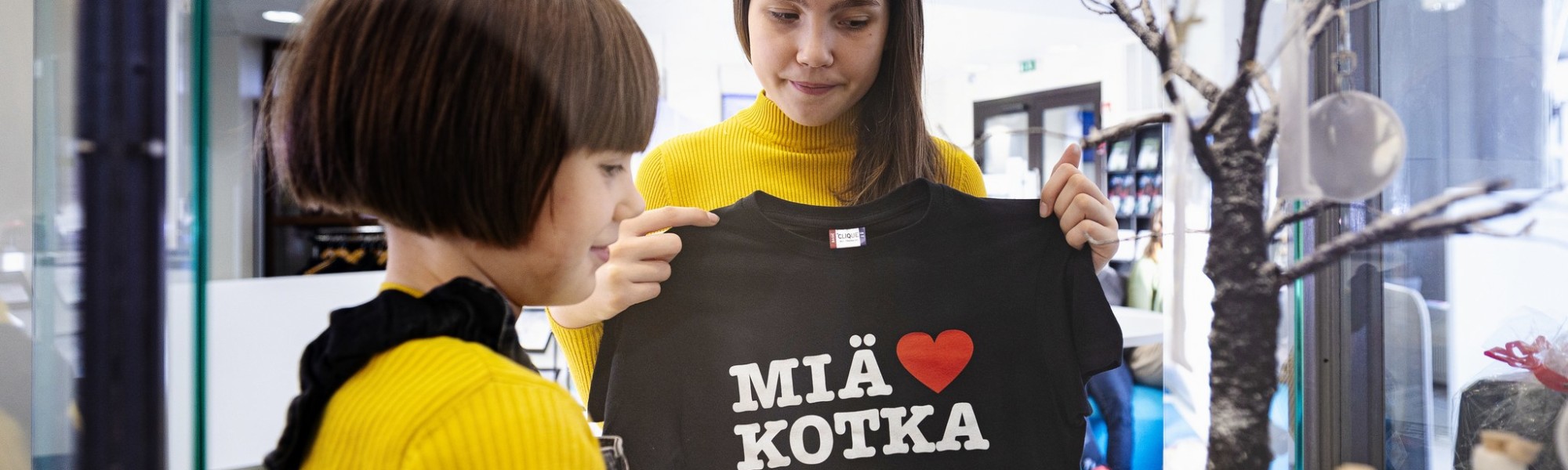 Kaksi lasta, joista toinen pitelee Miä sydän Kotka -T-paitaa edessään