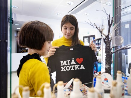 Kaksi lasta, joista toinen pitelee Miä sydän Kotka -T-paitaa edessään