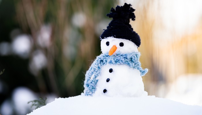 Lumiukolla on musta pipo ja vaaleansininen kaulaliina.