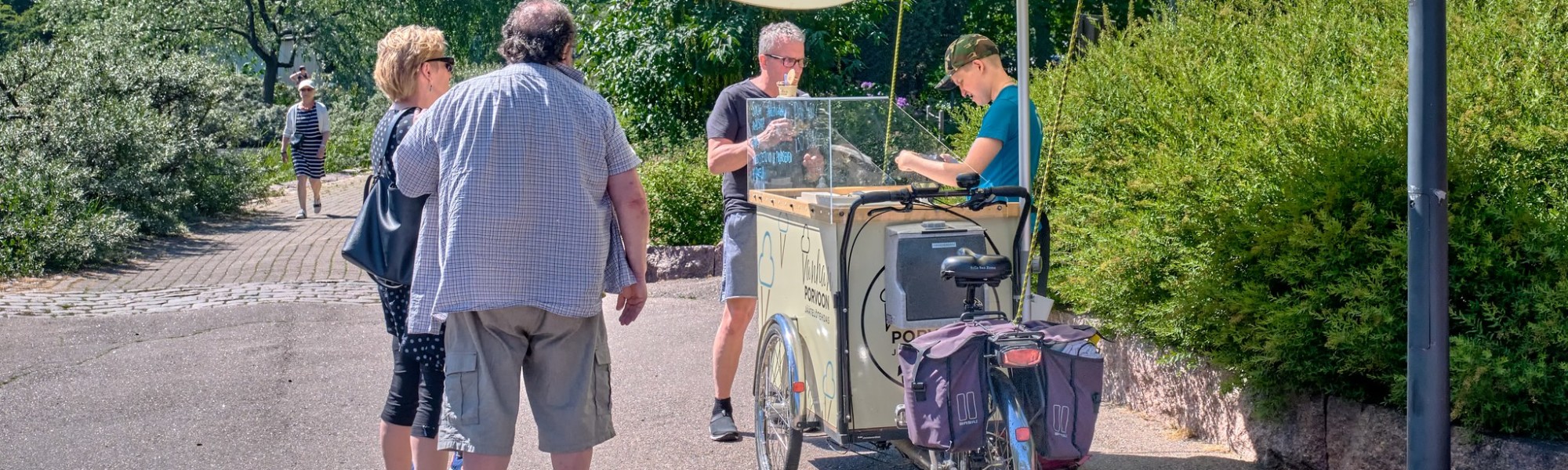 Pop up -jäätelökioski Sapokassa. Myyjä ja kolme asiakasta.