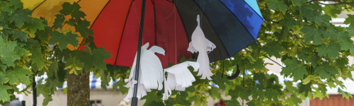 Puun oksissa kiinni iso värikäs sateenvarjo