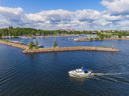 Ilmakuva mereltä Sapokan venesatamaan päin. Etualalla vene ja aallonmurtaja.