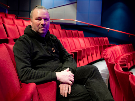Kuvassa Miko Jaakkola istumassa teatterin penkeillä.