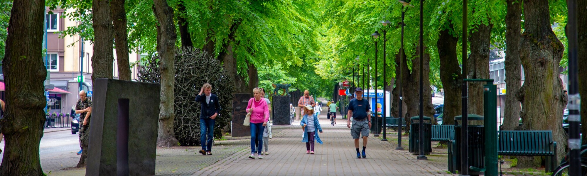 Lehmuskujalla kävelee muutamia ihmisiä.