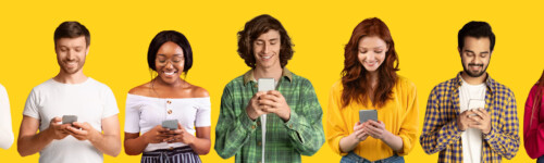 nuoret miehet ja naiset selaavat älypuhelimillaan nettiä, tarkistavat somea ja opiskelevat verkossa keltaisella studiotaustalla