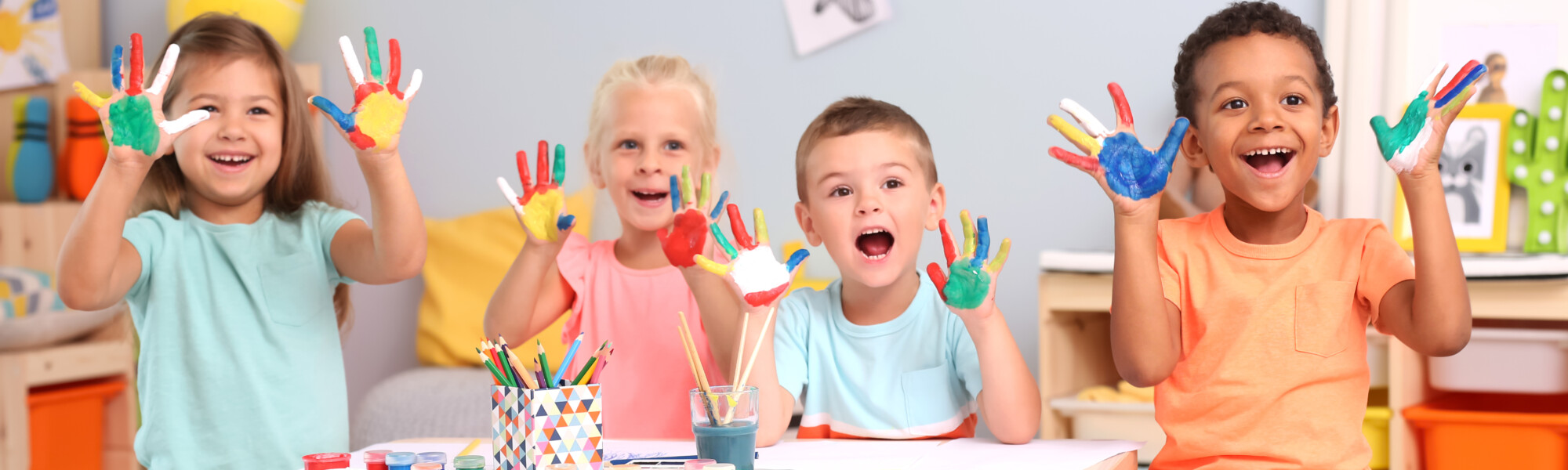 Iloisia lapsia maalaamassa sormiväreillä
