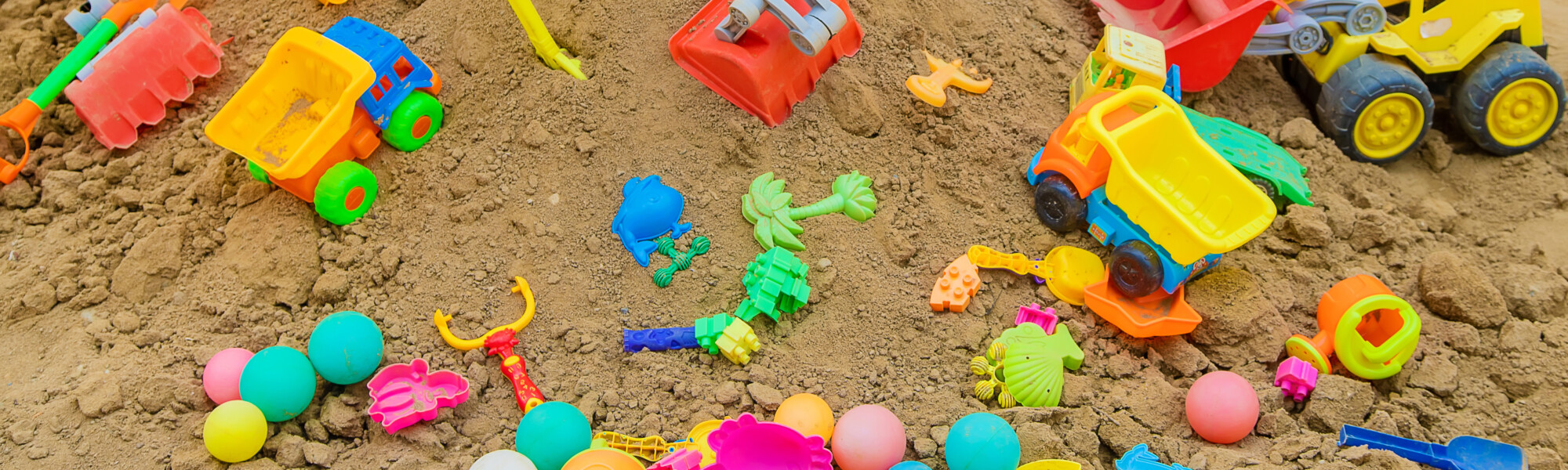 Hiekkalaatikolla on paljon lasten leluja