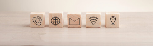 Puinen kuutiopalikka, jossa on viestinnän, sähköpostin, osoitteen ja Wi-Fi:n ikonit. Verkkosivun 'Ota yhteyttä' -osio tai sähköpostimarkkinoinnin konsepti. Hakukonsolin käyttö verkkosivustosi kanssa."