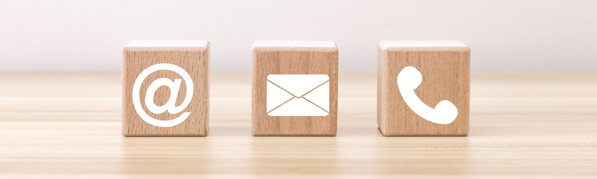 kolme puupalikkaa joissa symbölit sähköposti kirjekuori puhellinluuri