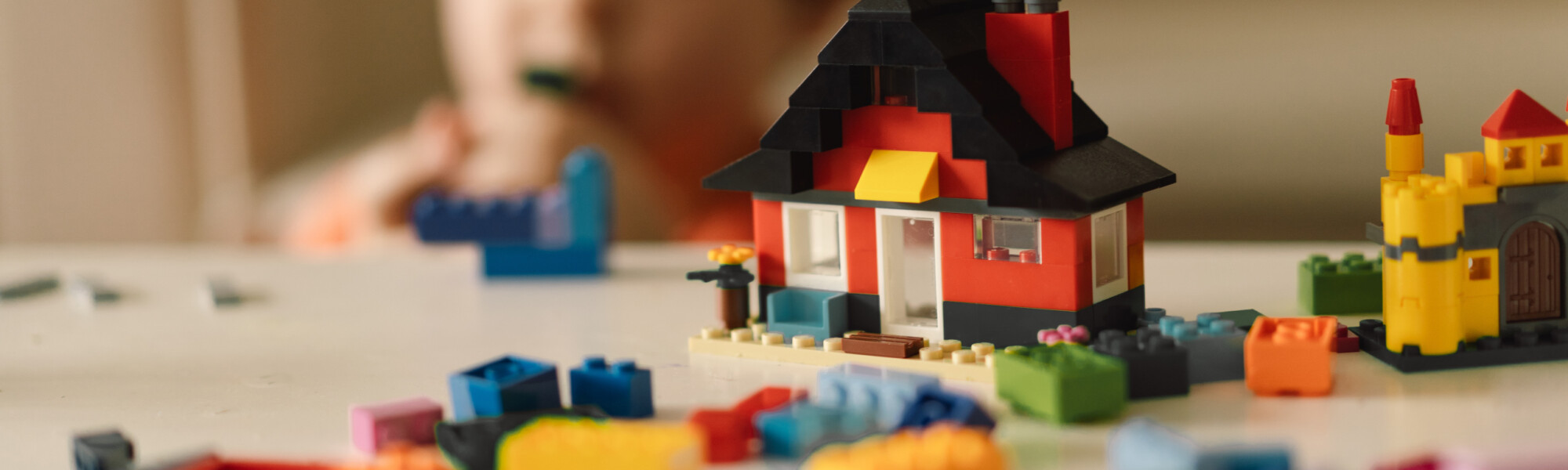 lapsi rakentaa legotaloa