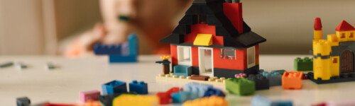 lapsi rakentaa legotaloa