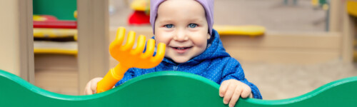 pieni iloinen poika katselee leikkipuistossa