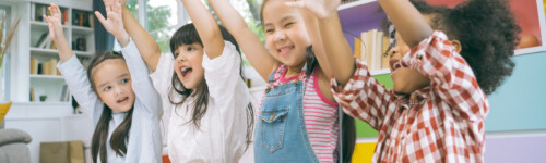 iloiset lapset nostavat käsiä