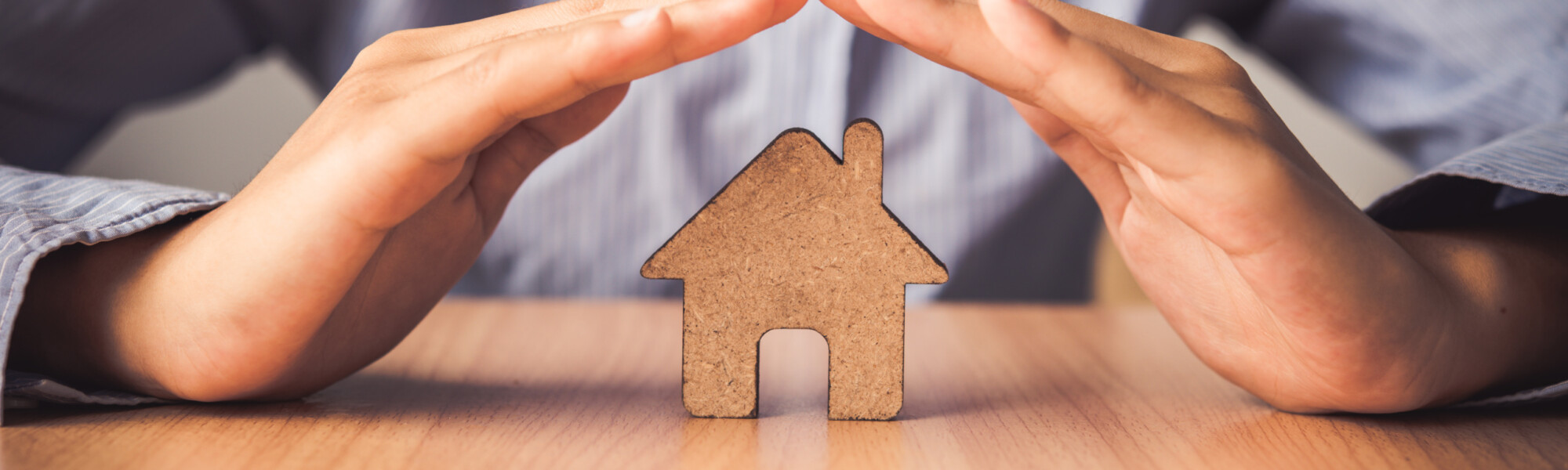 miehen kädet ovat talo silhuetin päällä