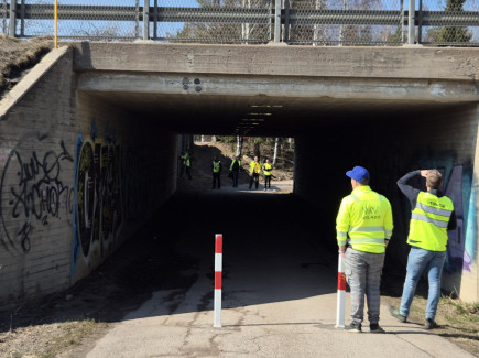 Sillan akka kulkeva alikulkutunnelli. Tunnelin edustalla kaksi työvaatteisiin pukeutunutta henkilöä.