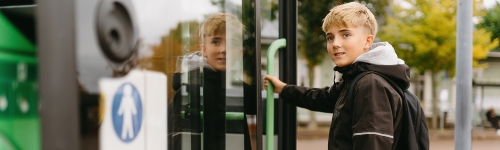 Lapsi nousee sähköbussin kyytiin.